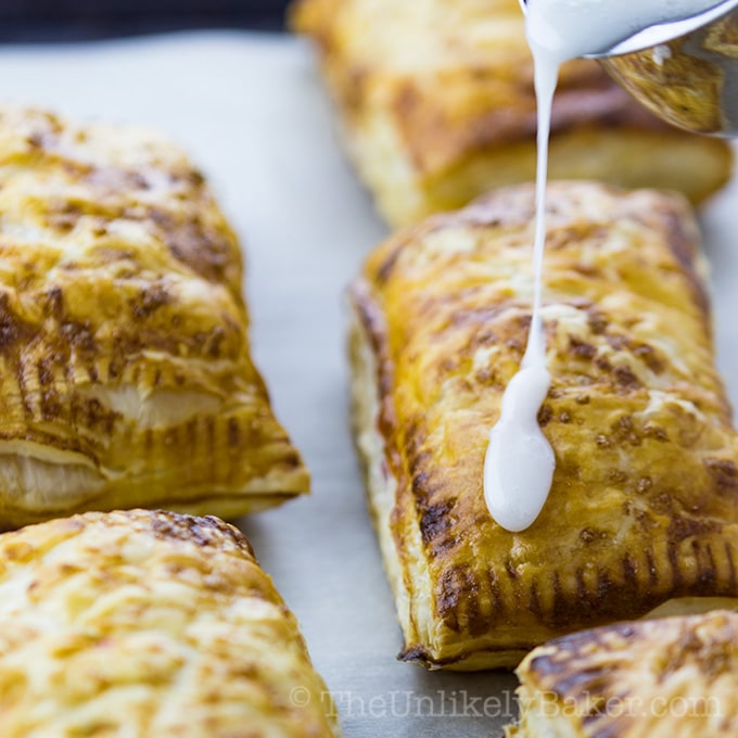 Puff Pastry Cherry Hand Pies with Glaze on a Pan.