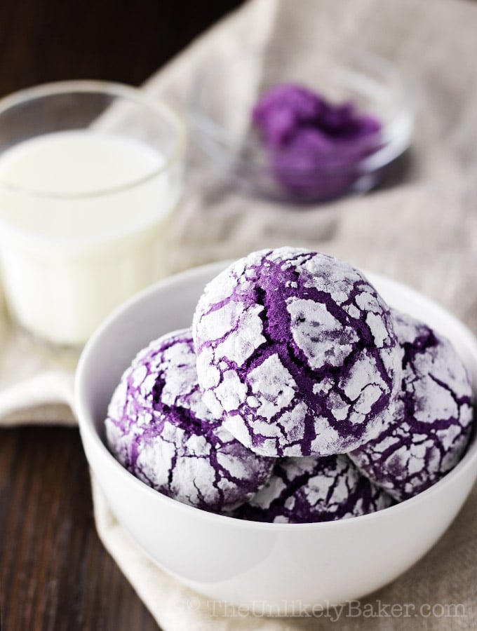 Ube crinkles in a bowl with a glass of milk in the background.