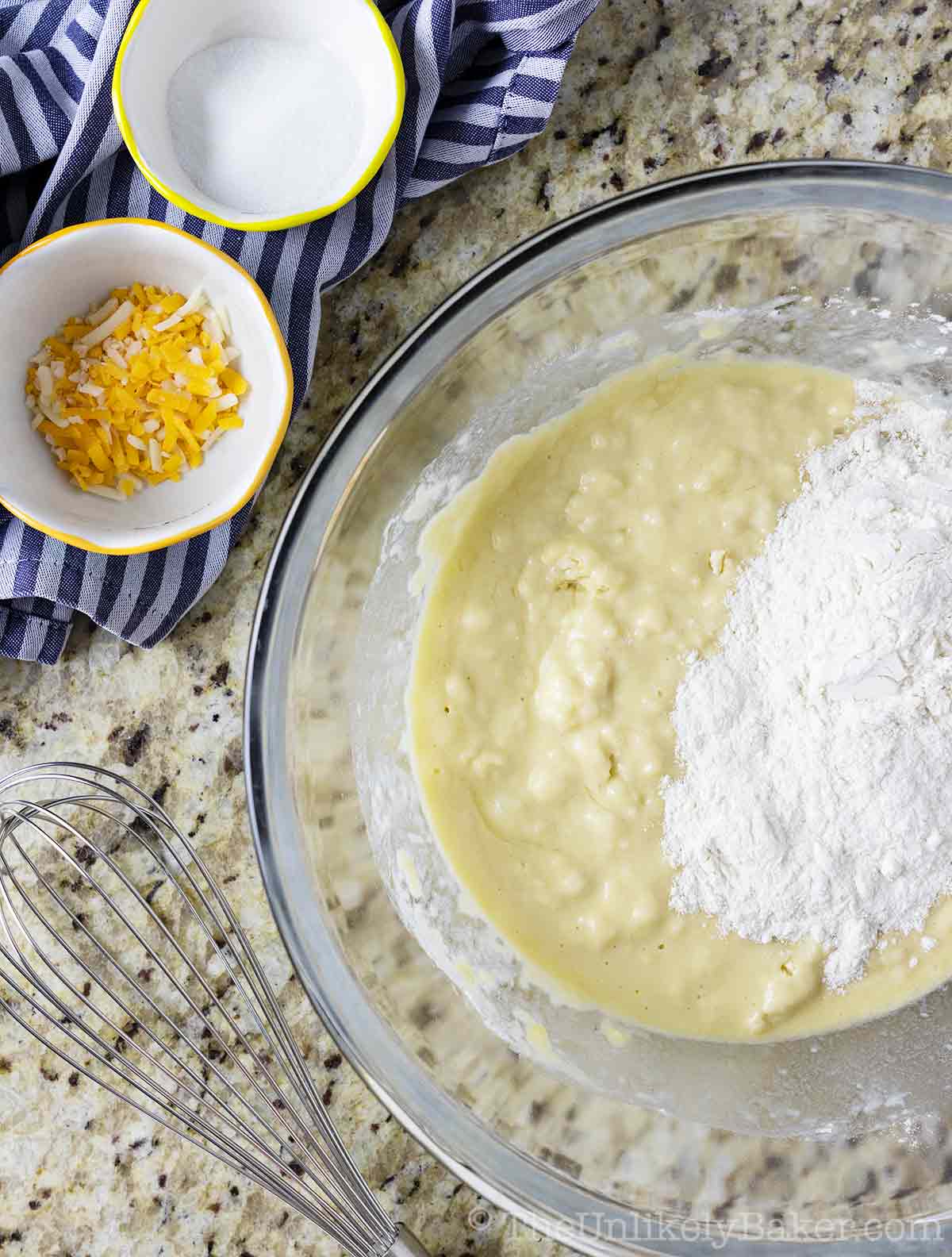 Flour added to wet ingredients in a bowl.