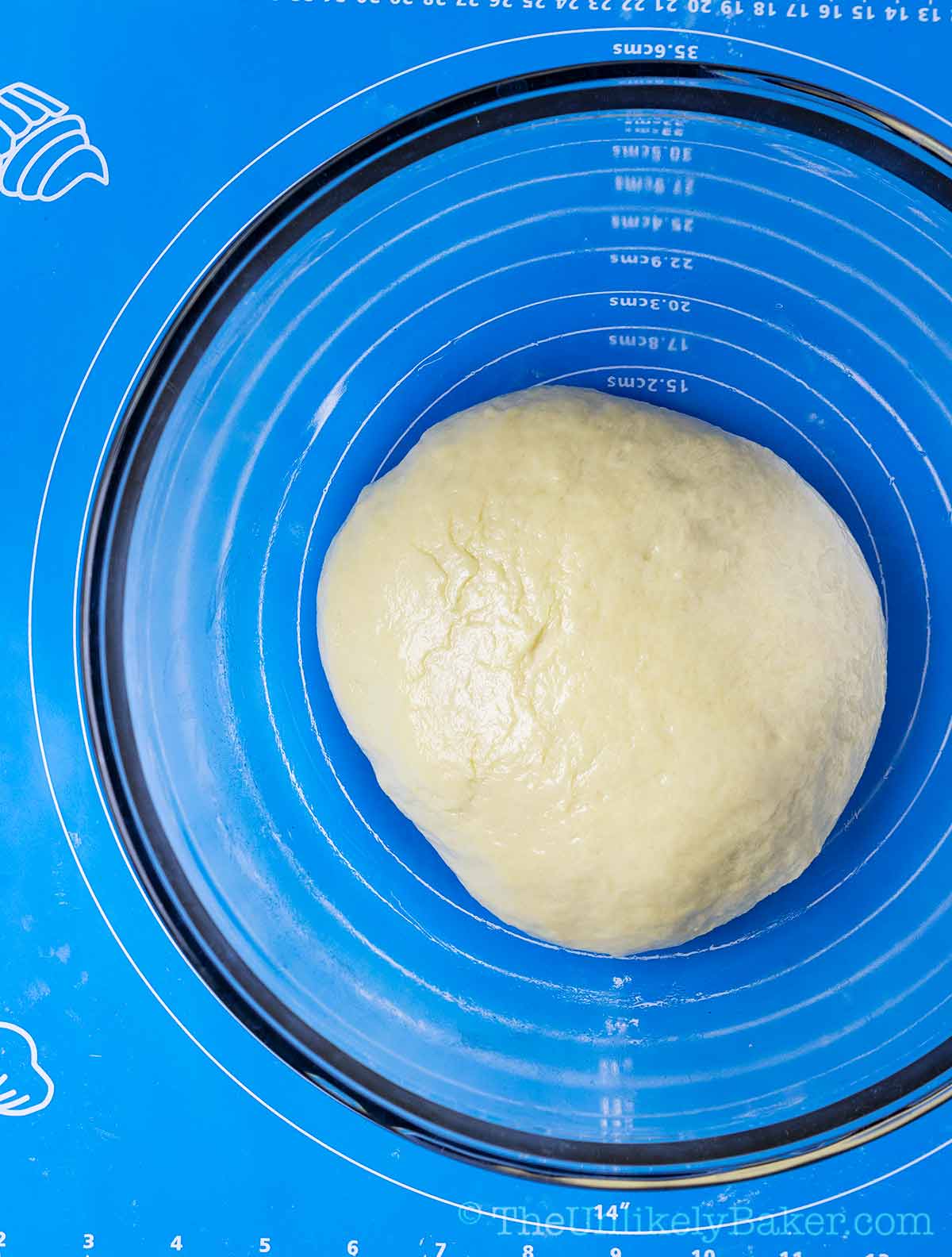 Oiled ube bread dough in a bowl.