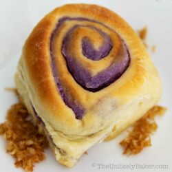 Ube bread roll on a white plate.
