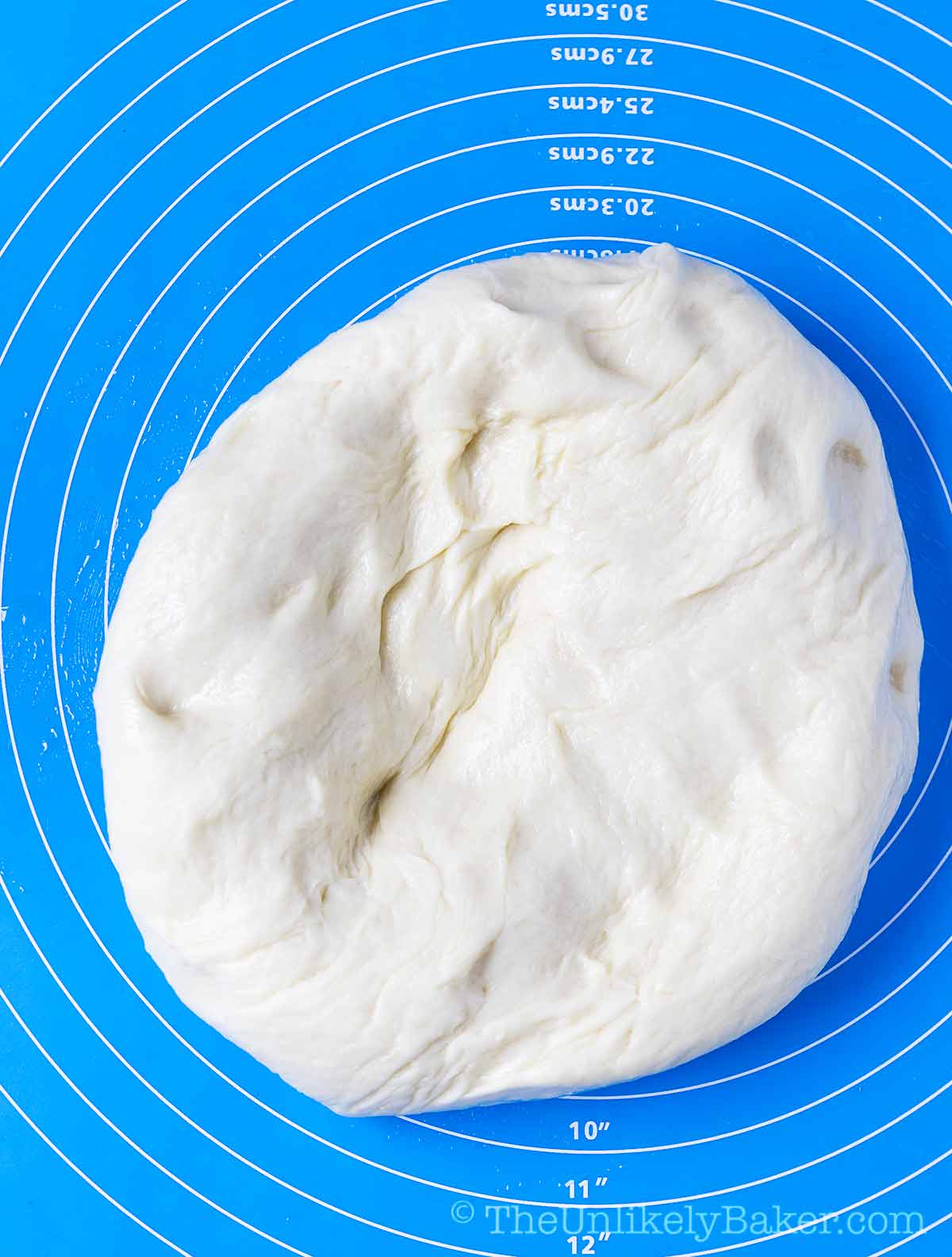 Freshly risen bread dough on a pastry mat.
