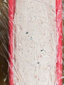 Strawberry and chocolate ice cream covered with plastic wrap.