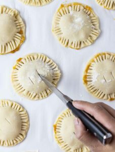 Cut the top of the pies to release air while baking.