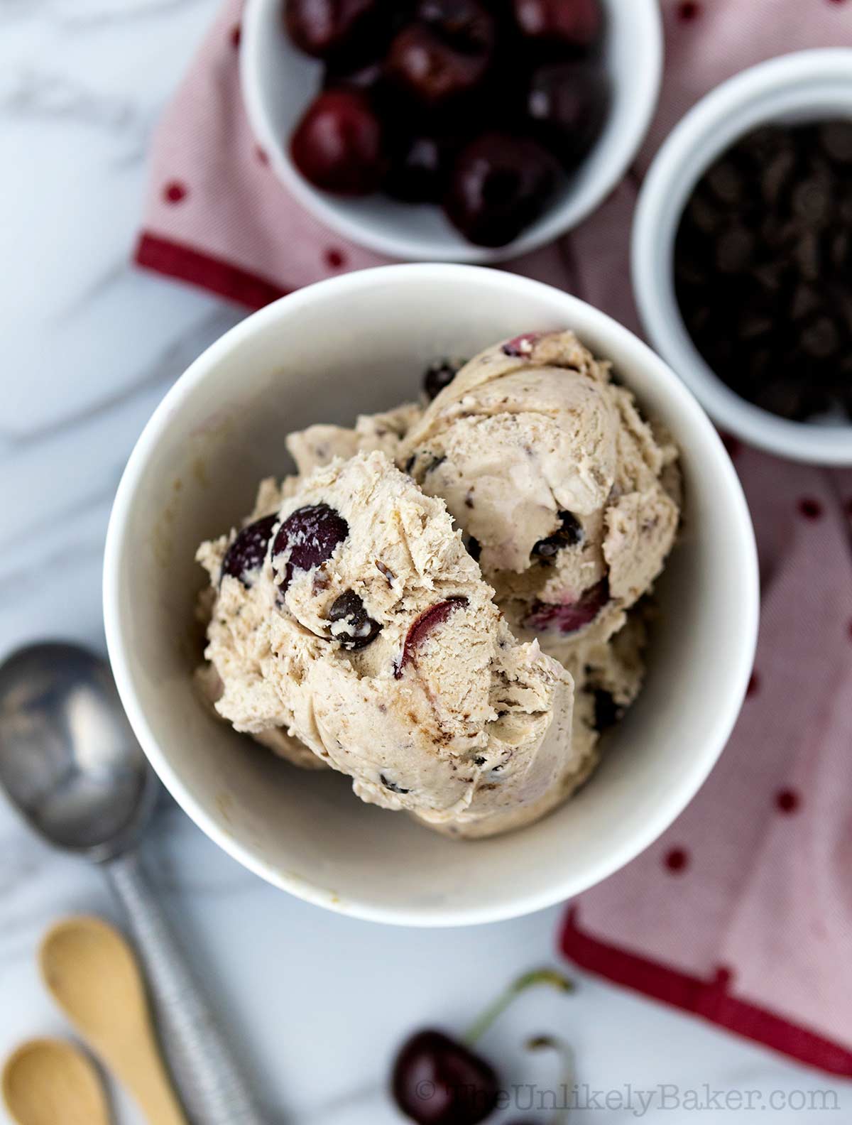 Scoop of cherry ice cream with chocolate chips in a bowl.