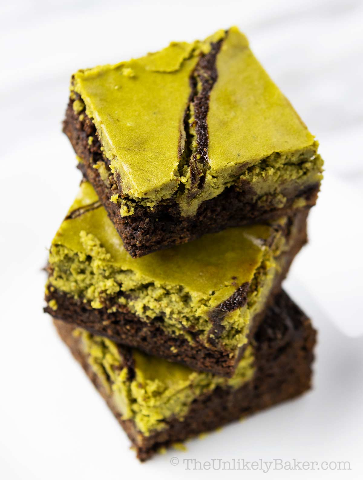 Chewy and fudgy matcha brownies on a white background.