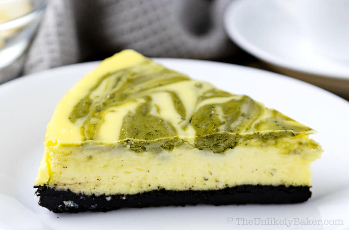 A slice of baked matcha cheesecake with Oreo crust.