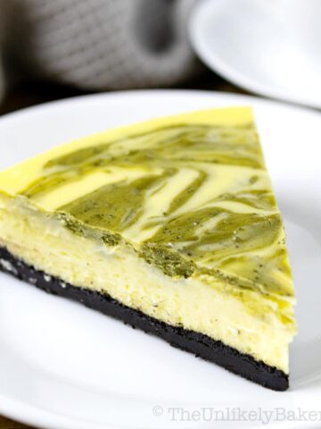 A slice of baked matcha cheesecake on a plate.