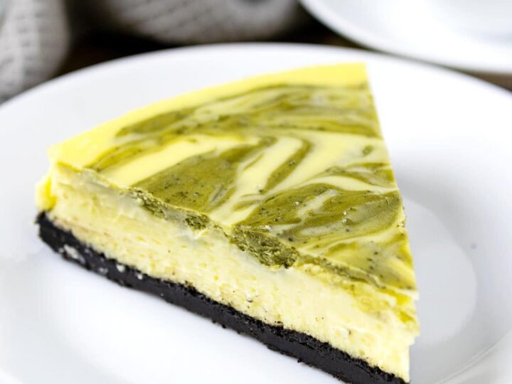 A slice of baked matcha cheesecake on a plate.
