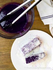 Dip ube bread in ube syrup and coat in coconut