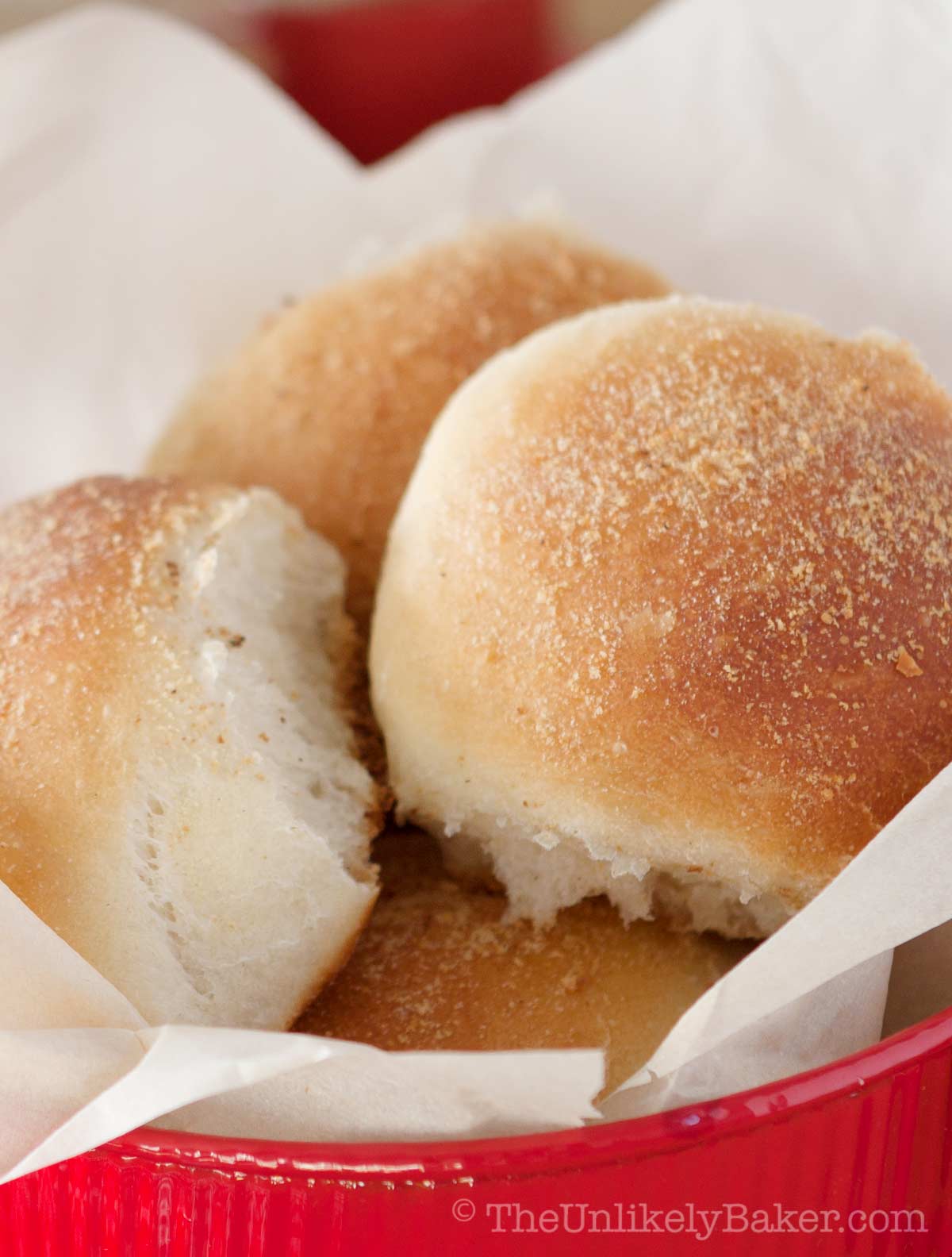 Freshly baked classic pandesal in a red tin