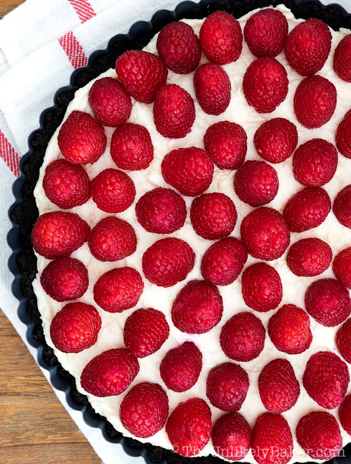 overhead shot of white chocolate tart with fresh raspberry topping