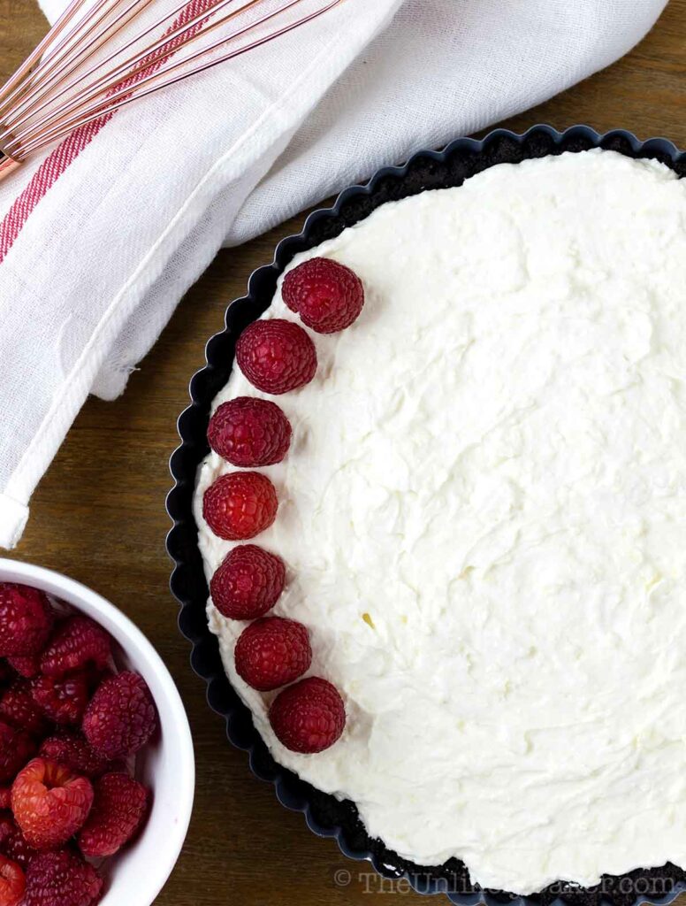 pieces of fresh raspberries placed on top of tart
