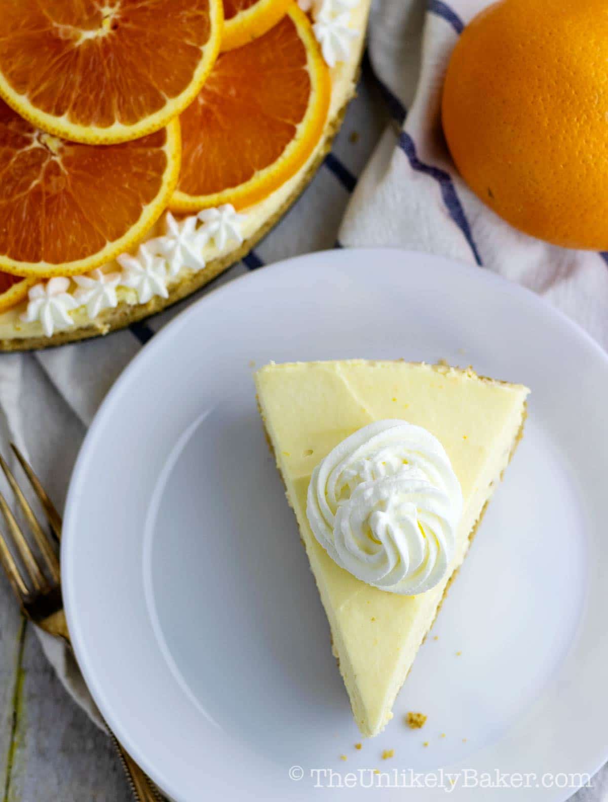 slice of orange cheesecake topped with whipped cream