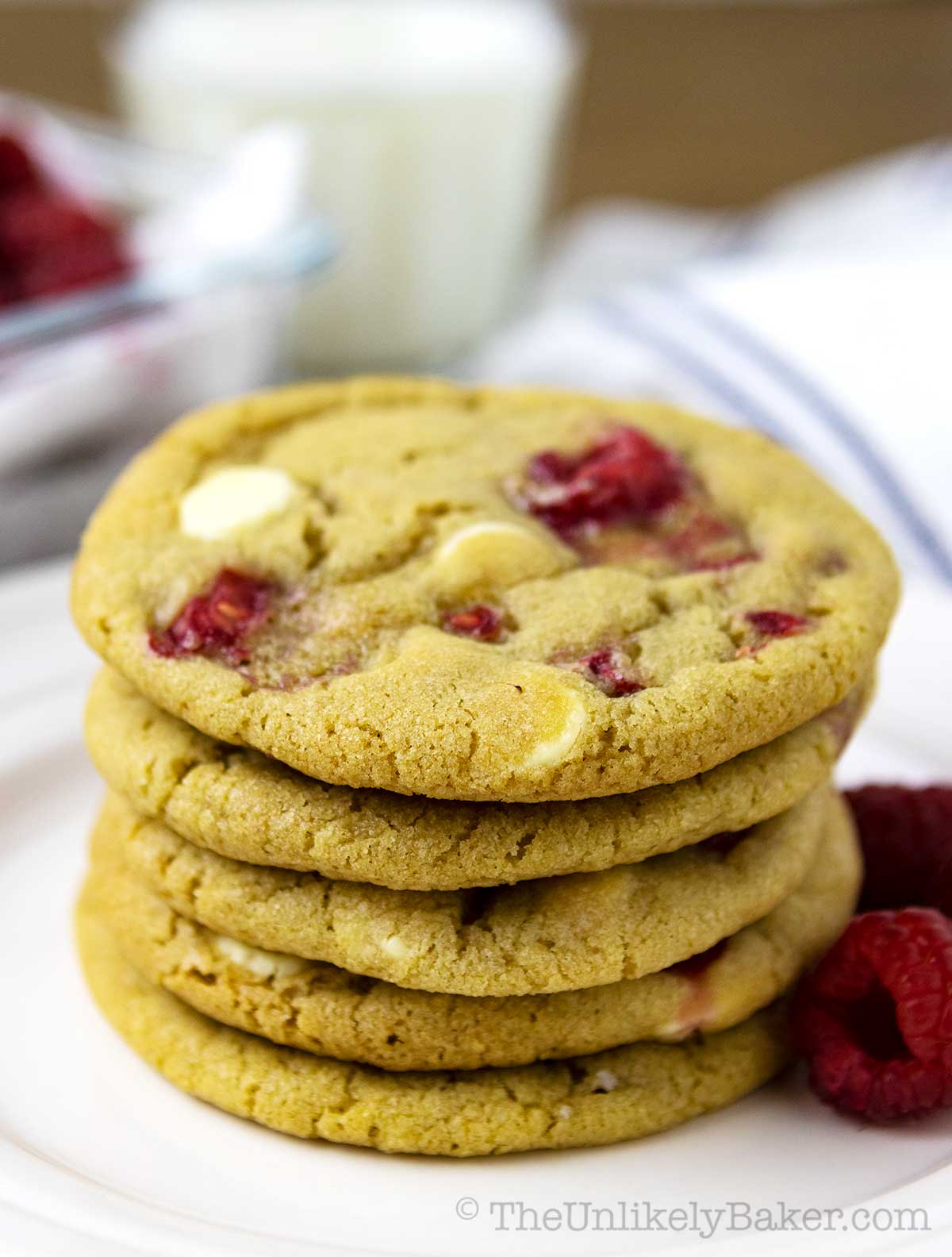 Tender raspberry and white chocolate cookies on a plate.