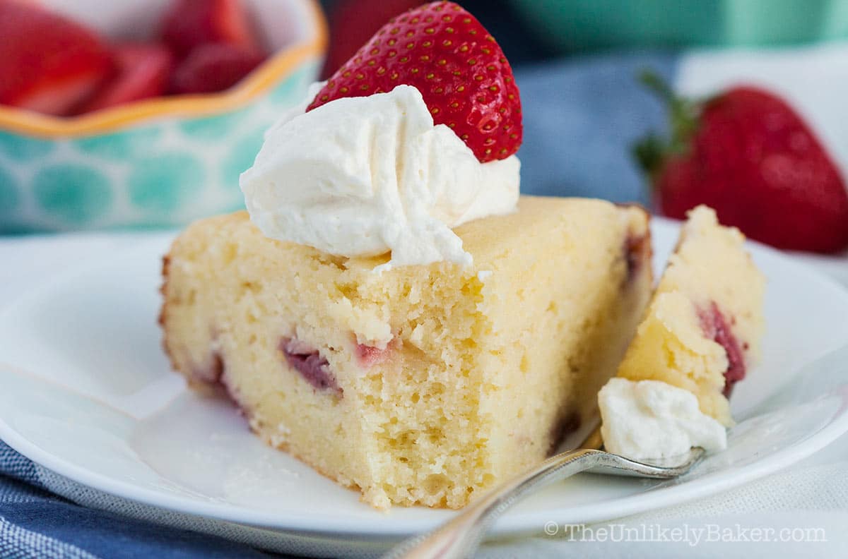 Slice of ricotta cake with strawberries and cream.