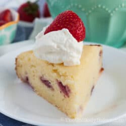 Slice of strawberry ricotta cake with whipped cream and strawberries.