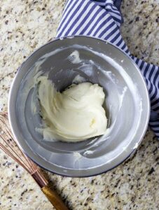 Cream cheese whipped with sugar in a bowl.