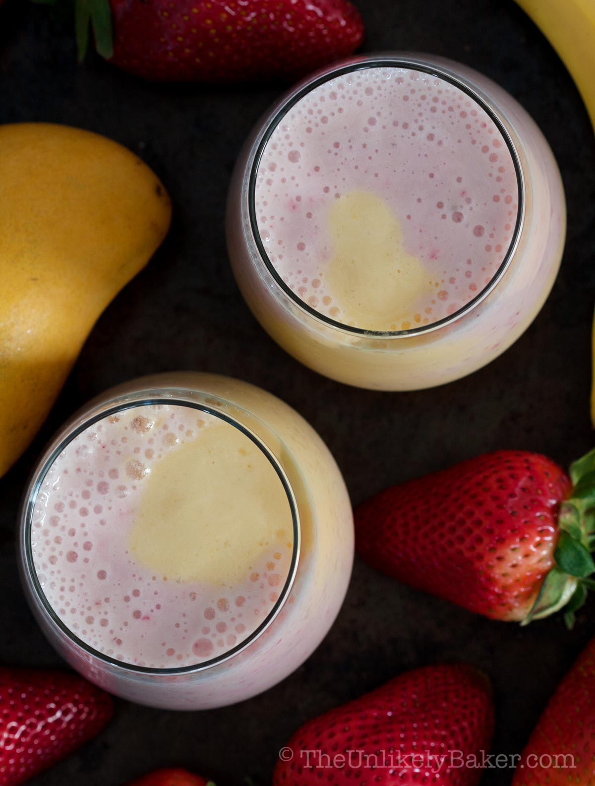 Two glasses of mango strawberry banana smoothie.