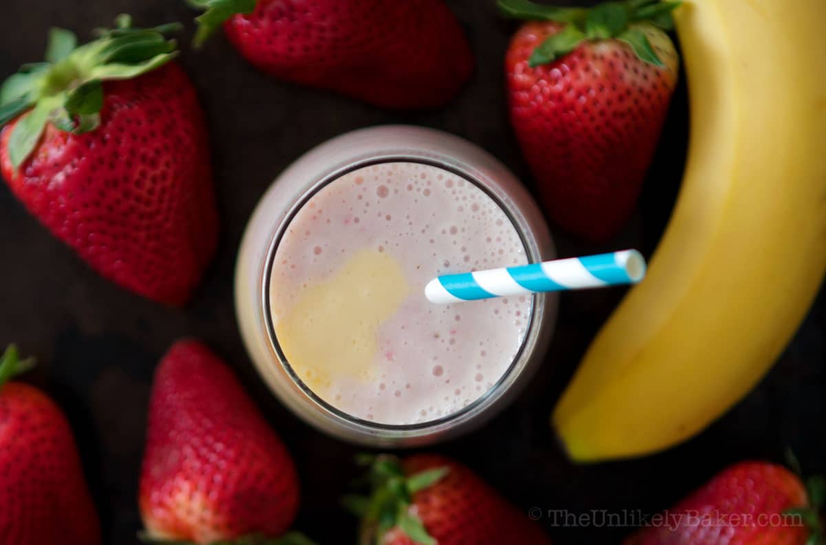 Thick and creamy strawberry banana mango smoothie in a glass.