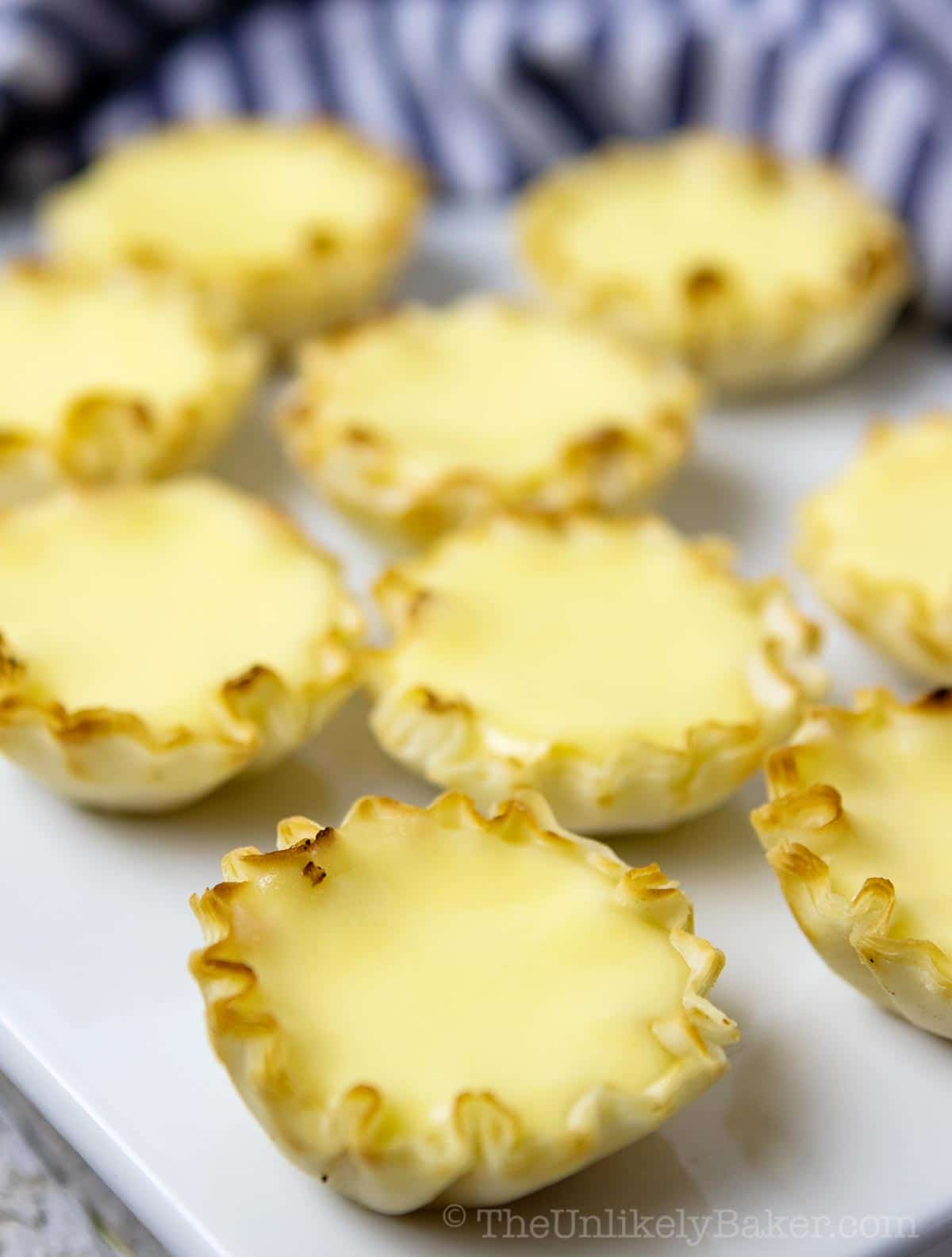Cheese egg tarts appetizers on a serving platter.