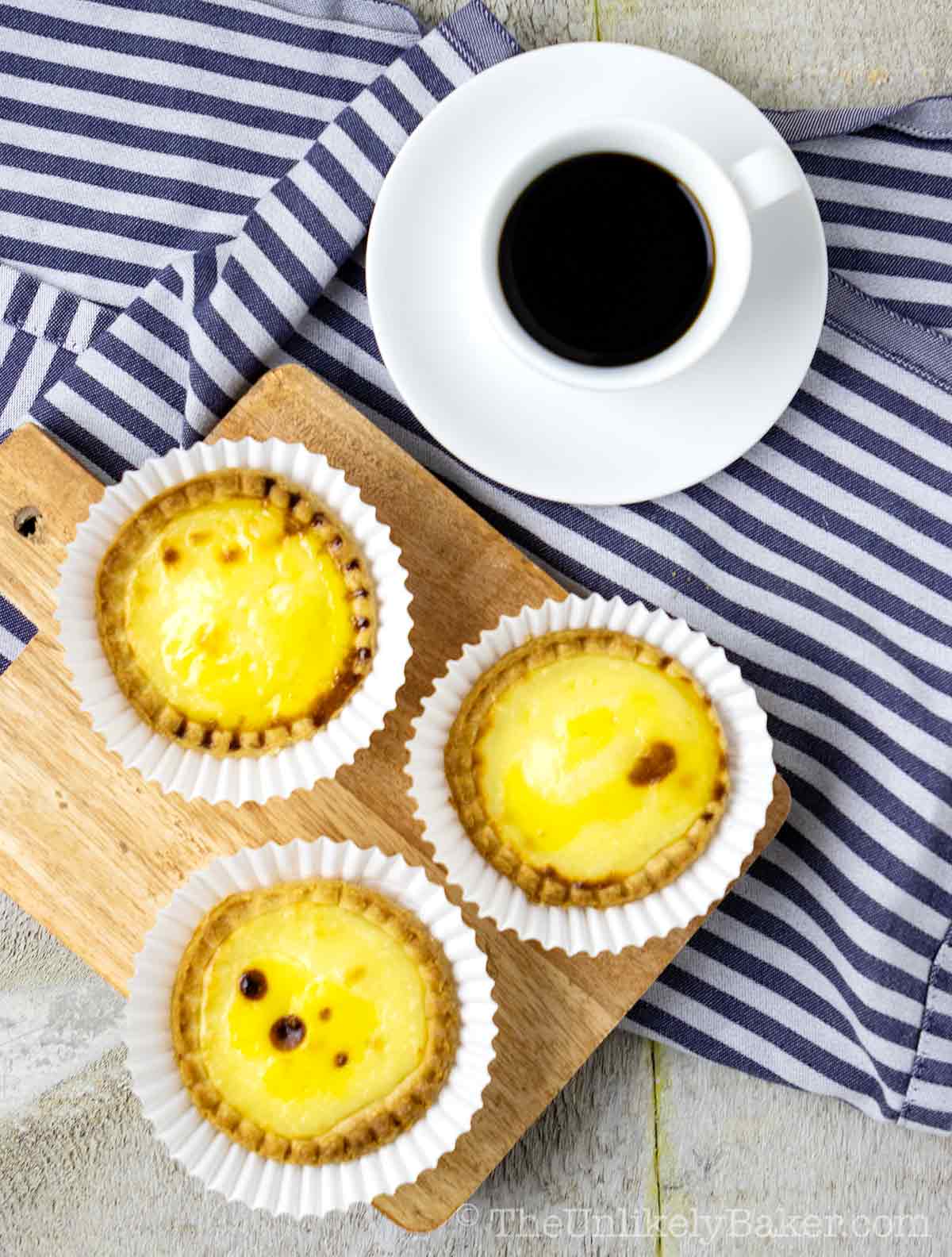 Hokkaido cheese tarts on a serving tray with coffee on the side.