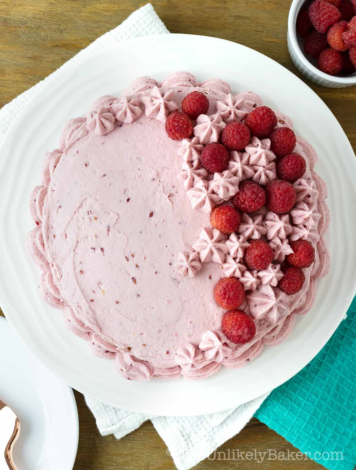 Raspberry and vanilla cake on a cake platter.