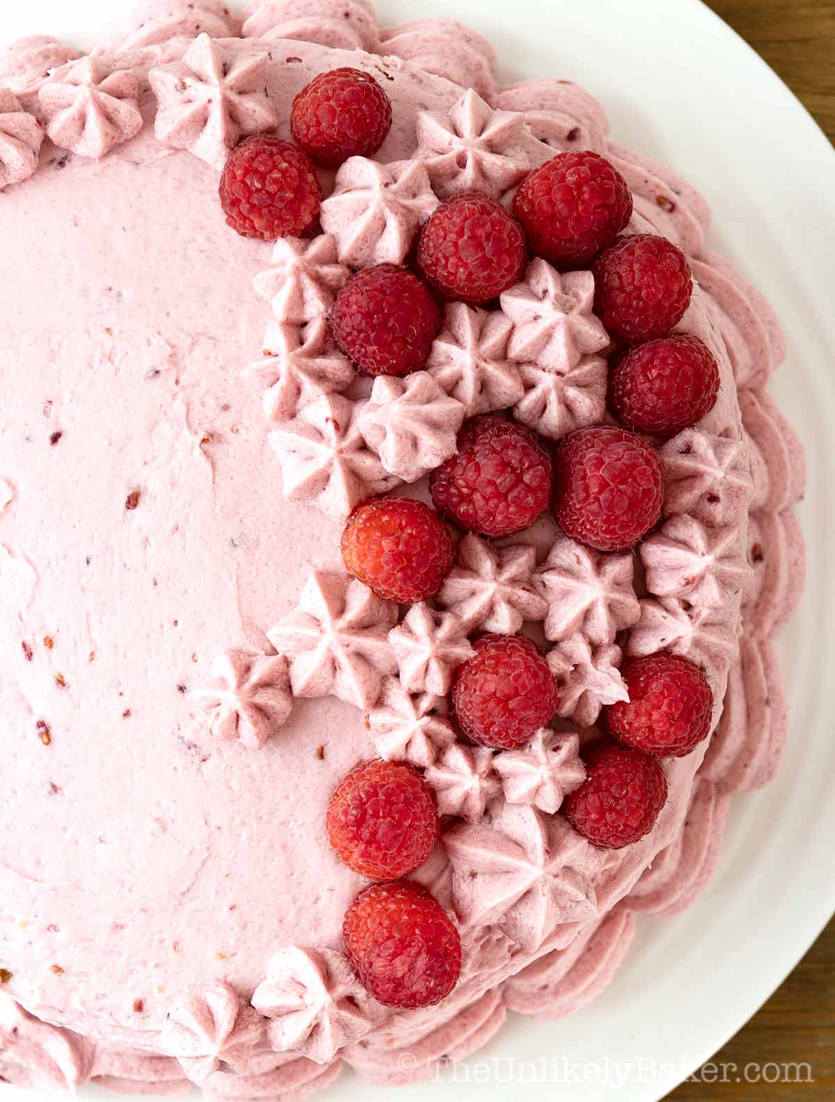 Vanilla raspberry cake topped with fresh raspberries.