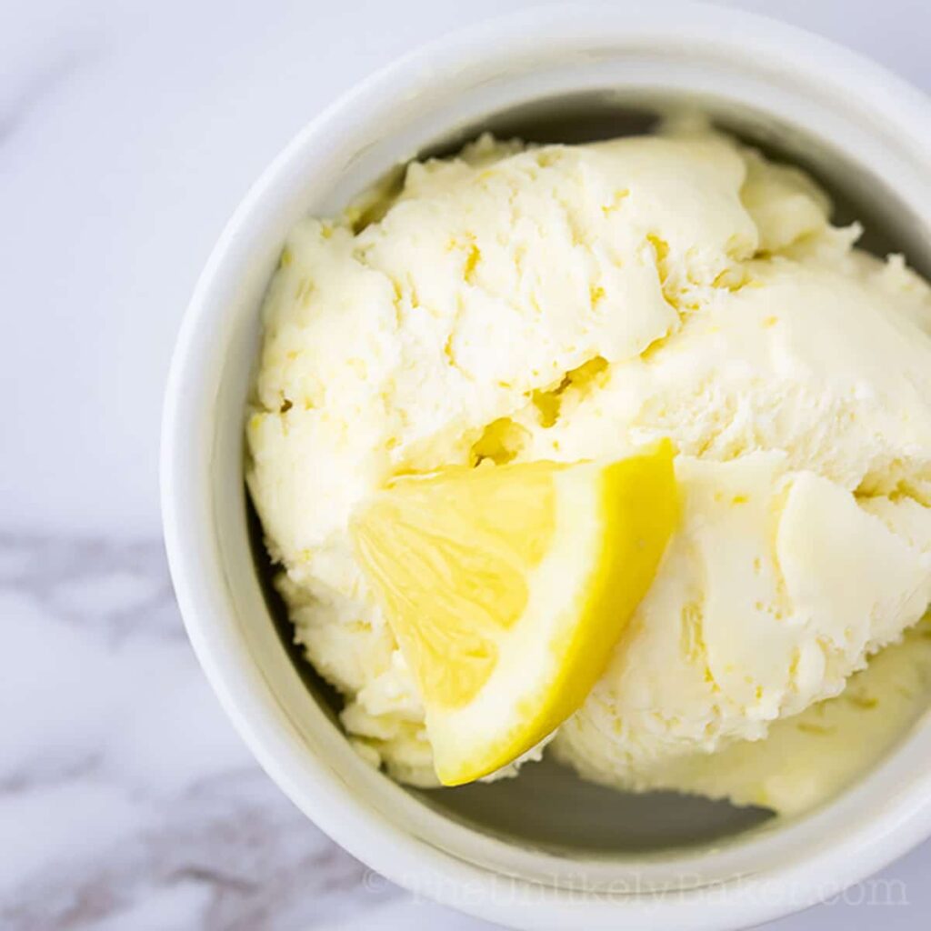 Lemon curd ice cream with a slice of lemon on top.