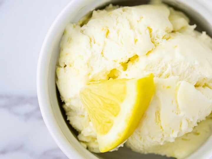 Lemon curd ice cream with a slice of lemon on top.