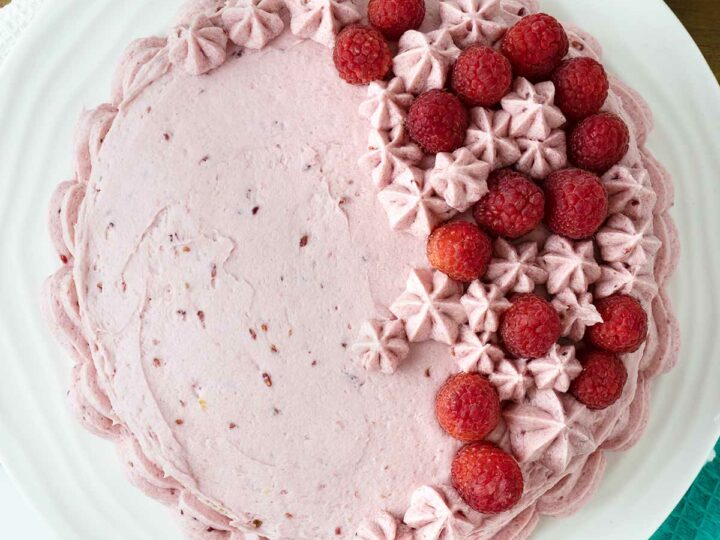 Vanilla raspberry cake decorated with fresh raspberries.
