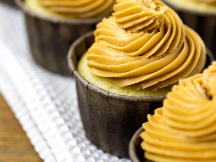 Dulce de leche cupcakes with dulce de leche frosting on a table.