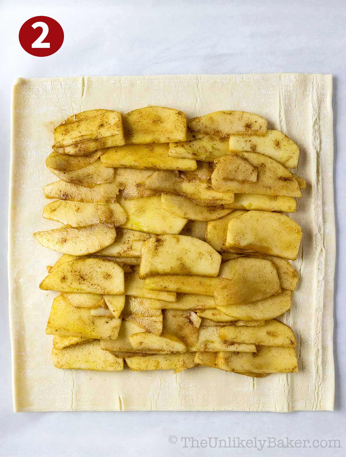 Cinnamon apples on top of a puff pastry crust.
