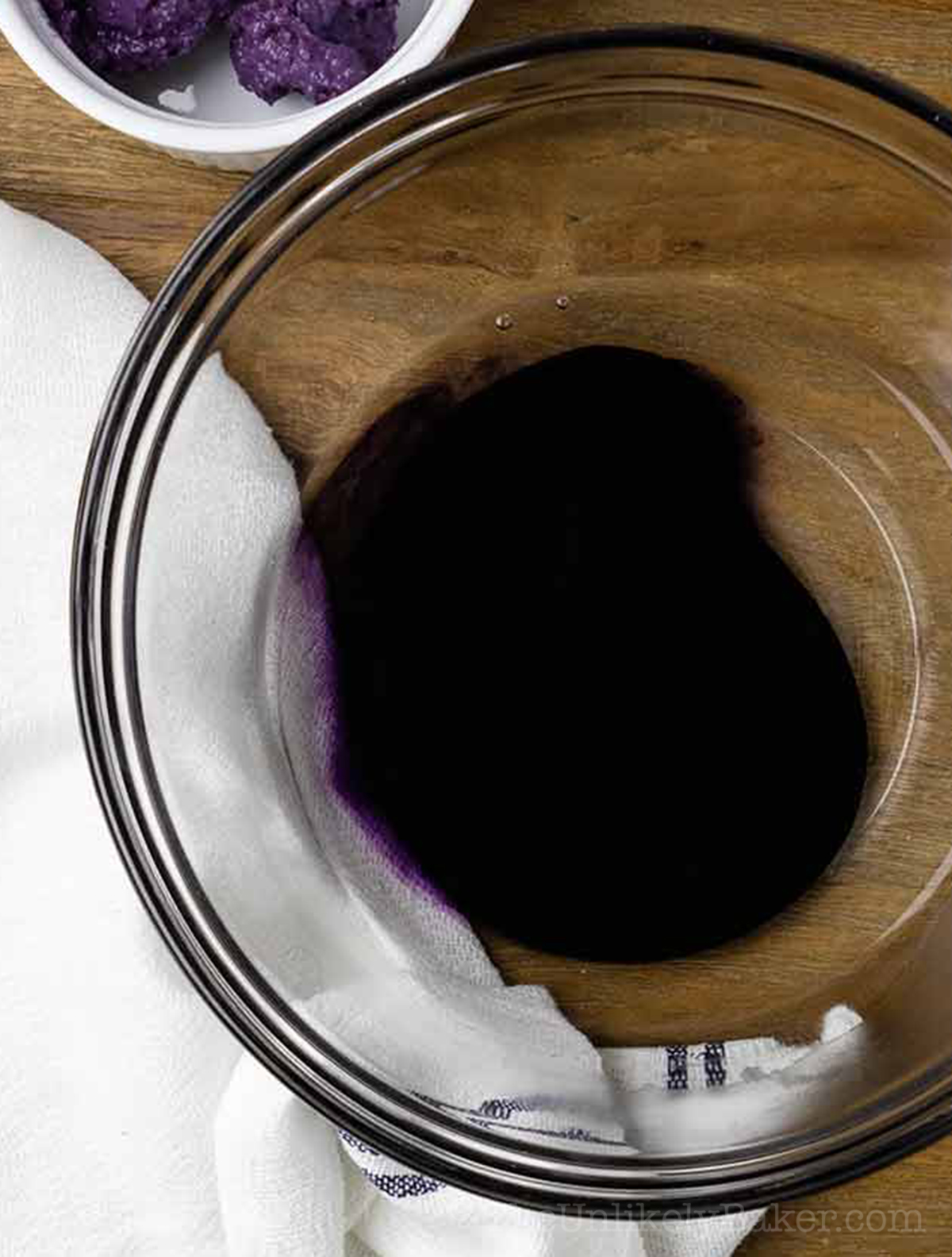 Ube extract and warm water in a bowl.