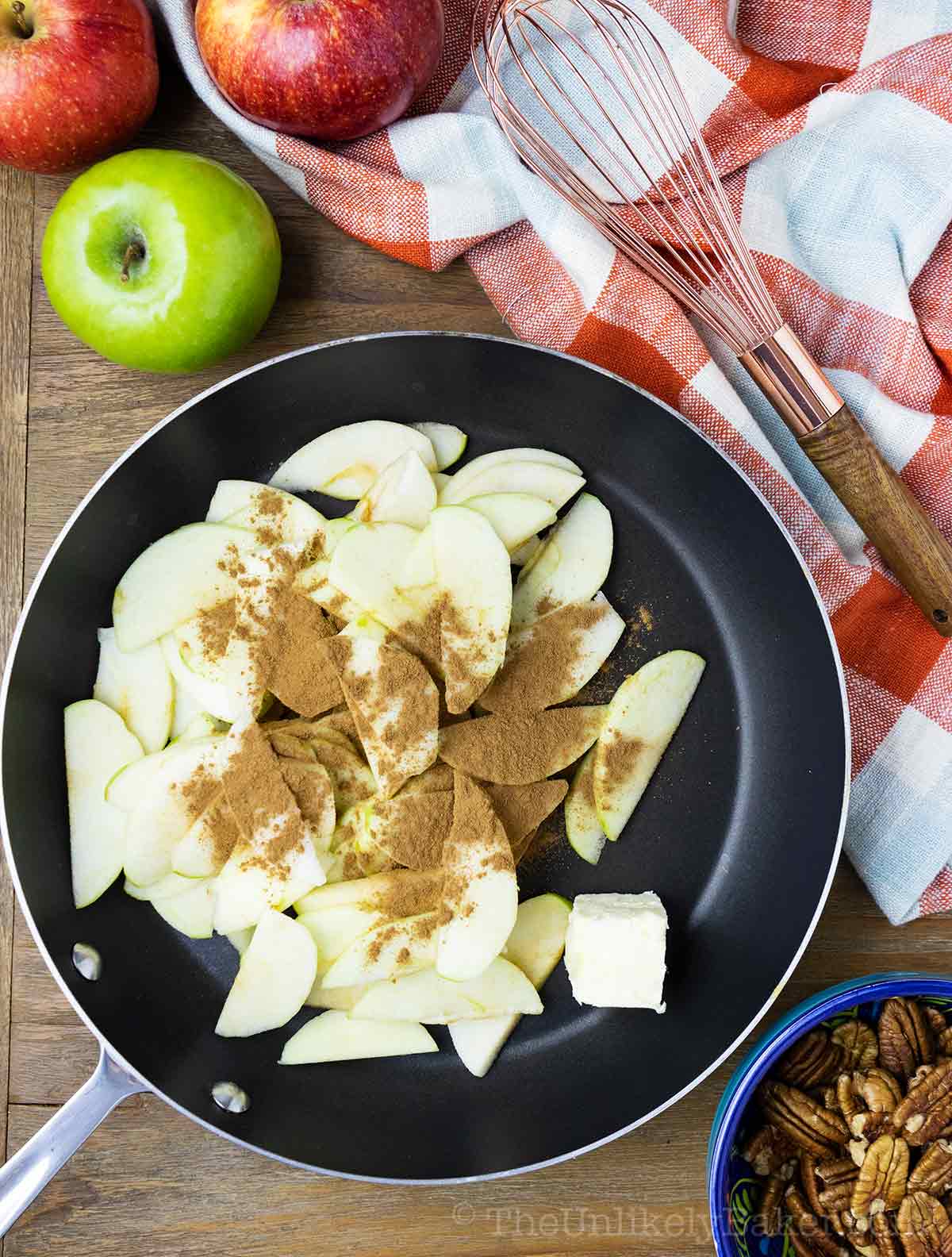Slices of apples with cinnamon on a pan.