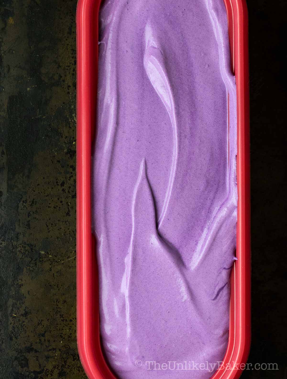 Creamy ube ice cream in an ice cream tub.