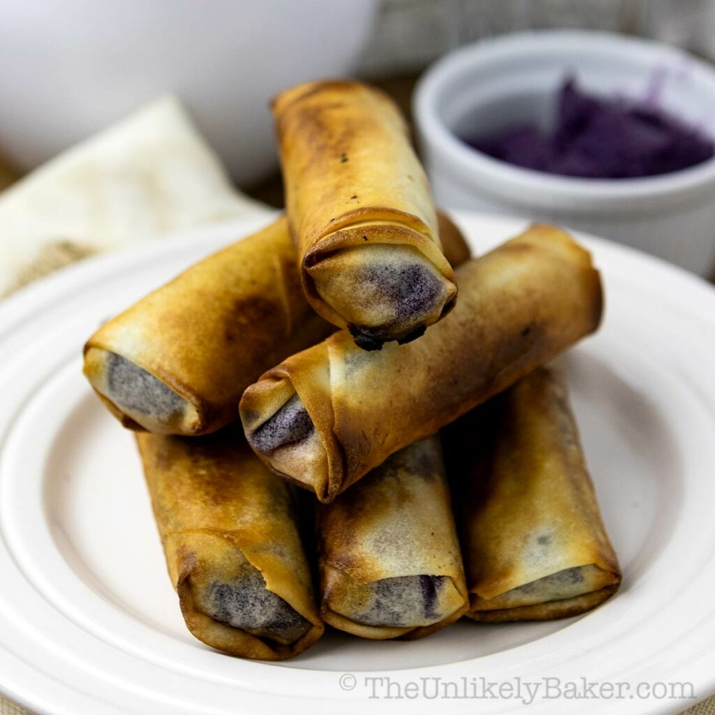 A stack of crispy ube turon on a plate.