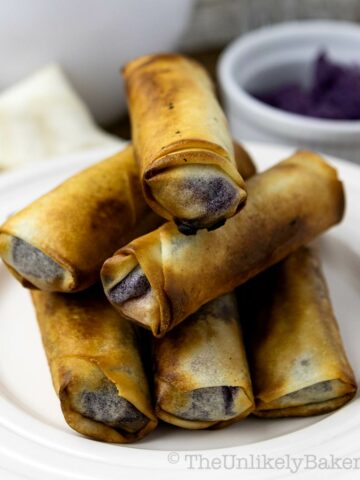 A stack of crispy ube turon on a plate.