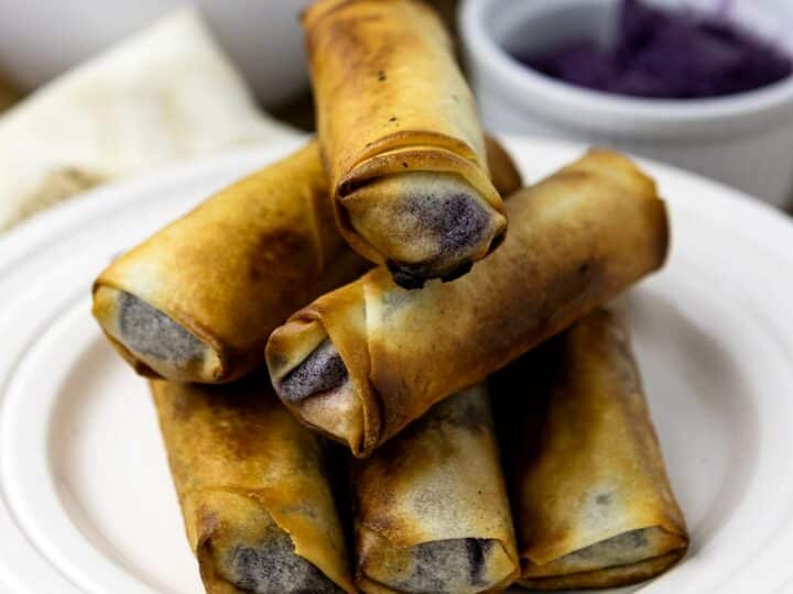 A stack of crispy ube turon on a plate.