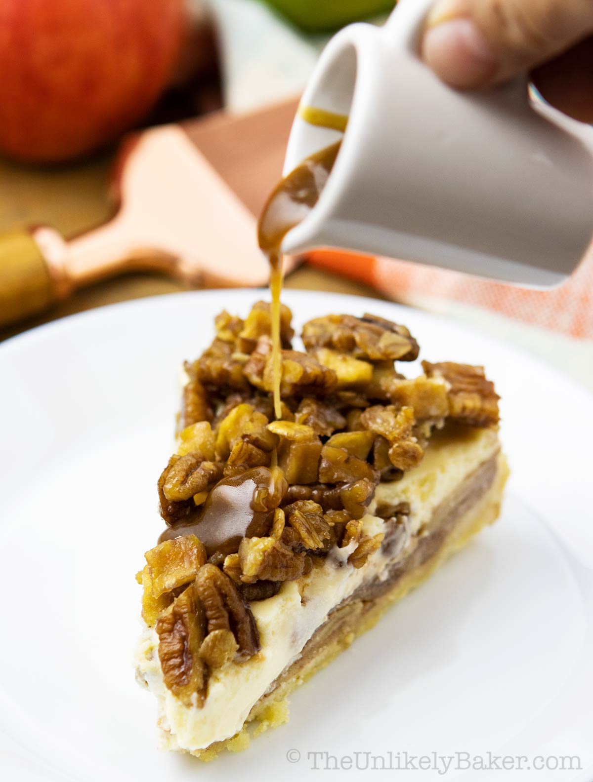 Caramel sauce poured over a slice of apple crumble caramel cheesecake.