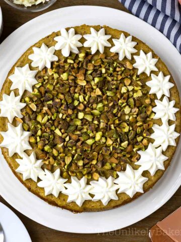 Overhead shot of pistachio cheesecake with whipped cream and chopped pistachios.