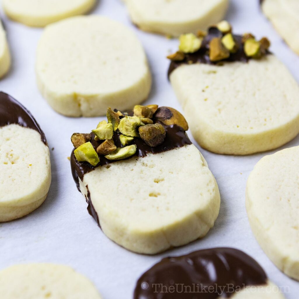 Mascarpone cookies dipped in chocolate and sprinkled with nuts.