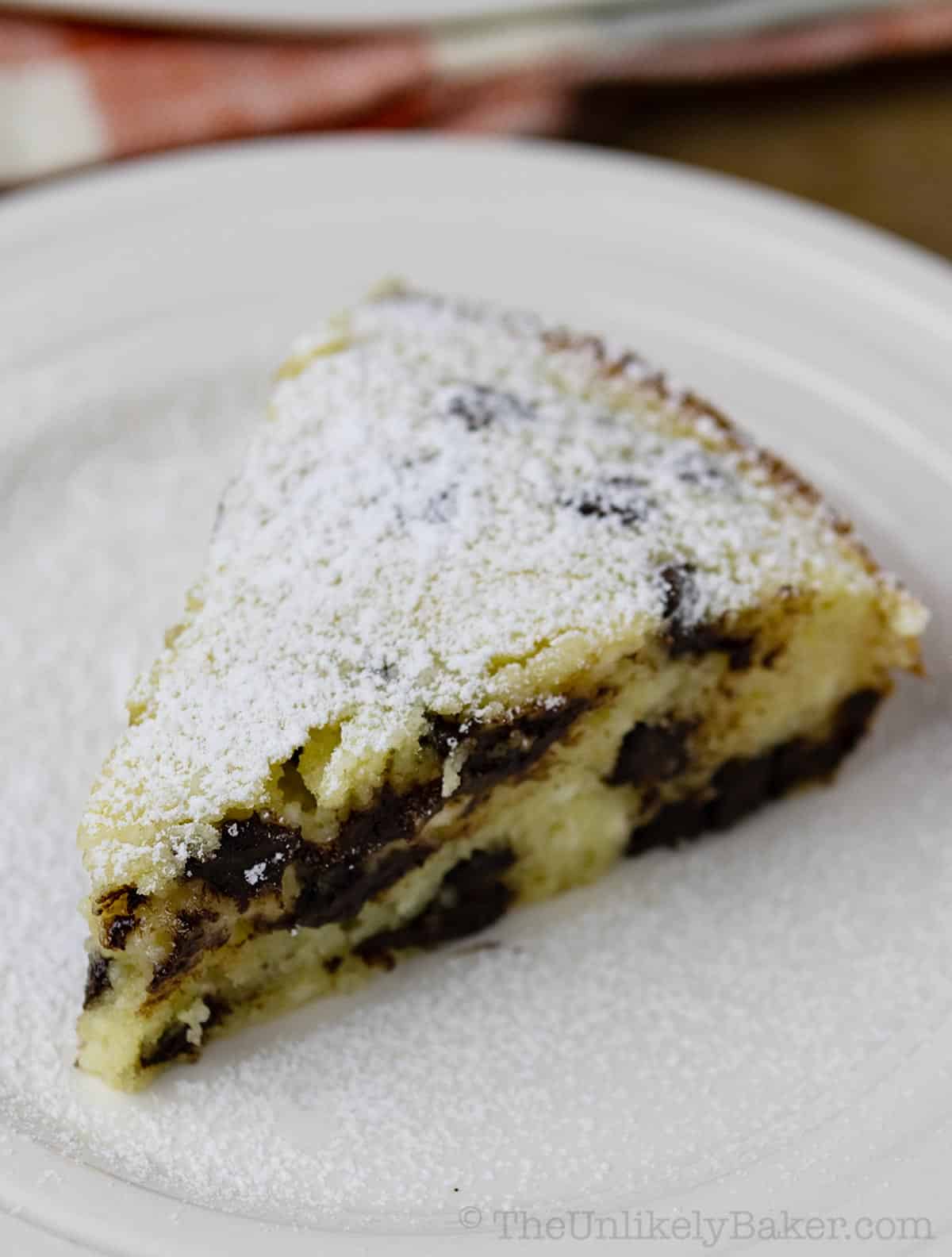 A slice of ricotta chocolate cake dusted with powdered sugar.
