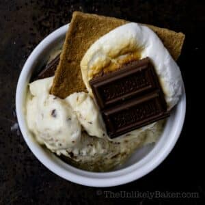 Scoops of marshmallow ice cream topped with s'mores.