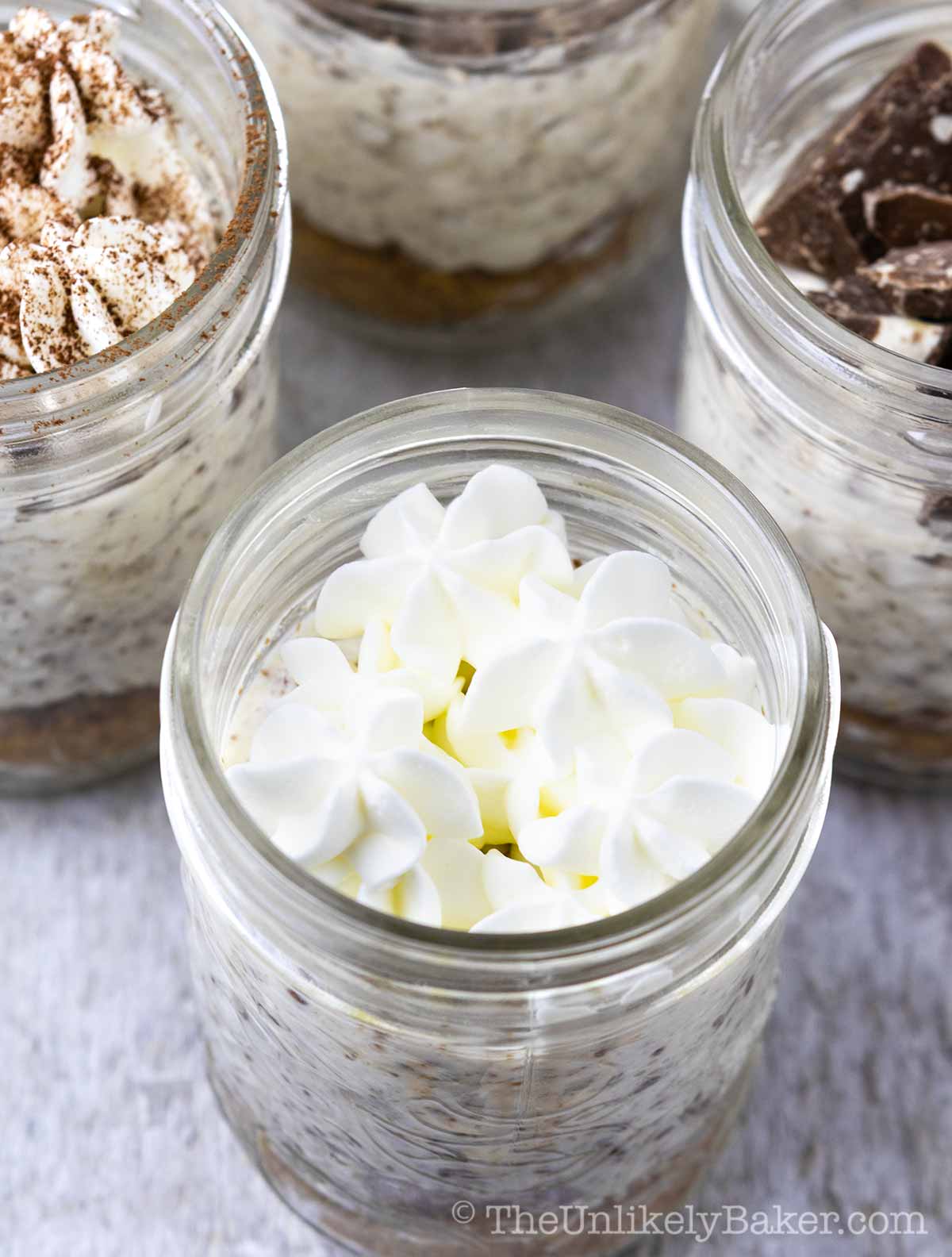 Toblerone cheesecake in jars topped with whipped cream.