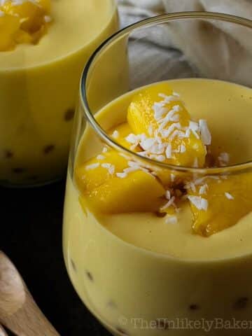 Closeup shot of mango chunks on top of a glass of mango sago.