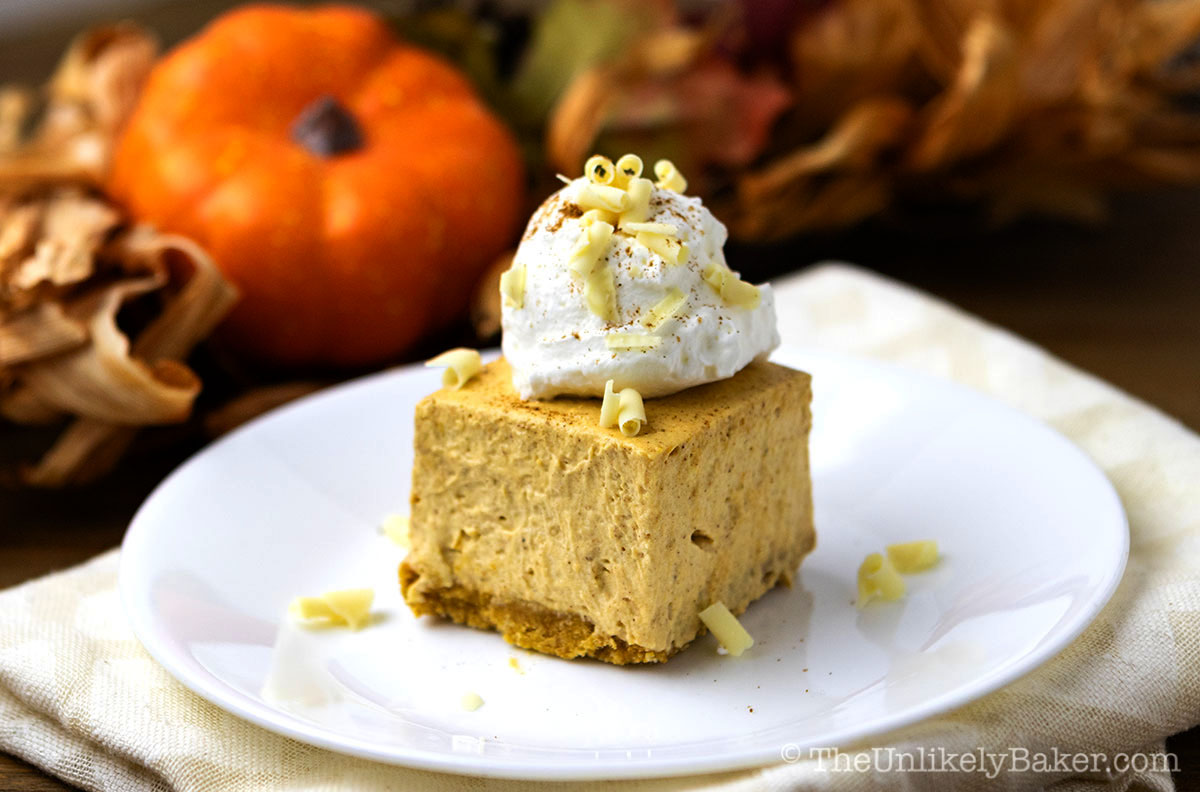 A piece of pumpkin cream cheese bars with whipped cream topping.