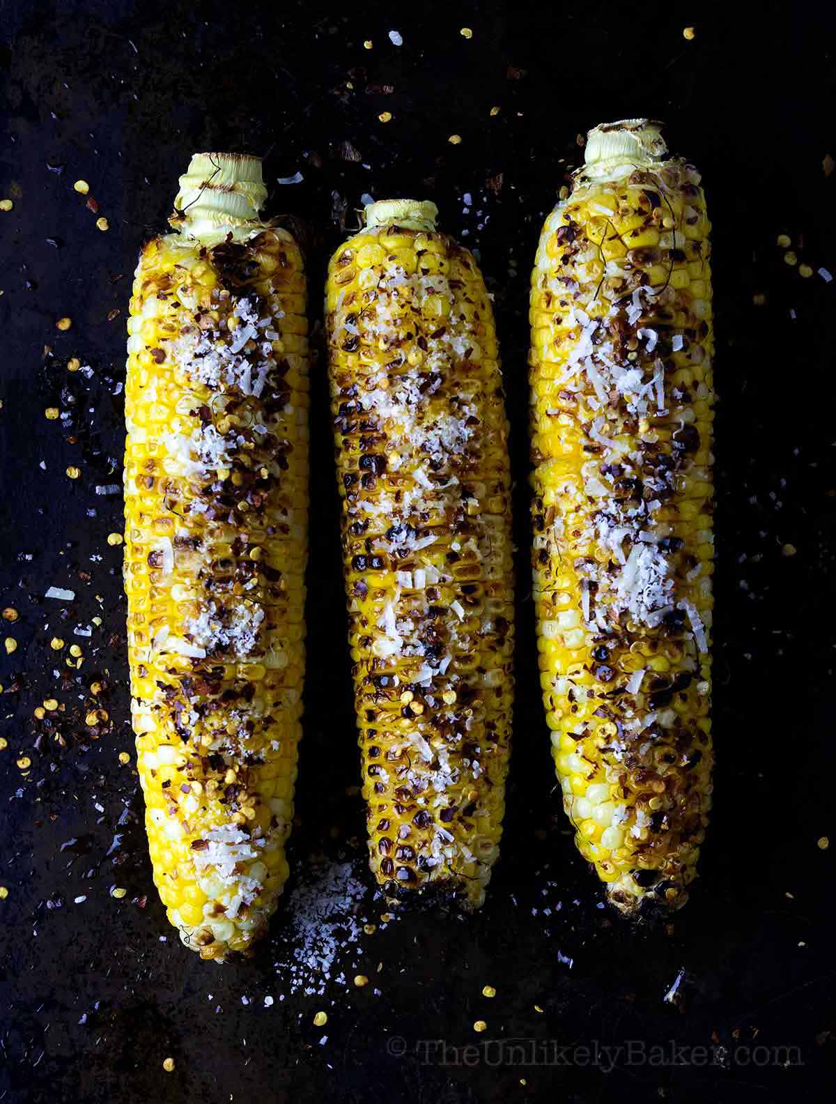 Chili corn on the cob with lime and parmesan cheese.