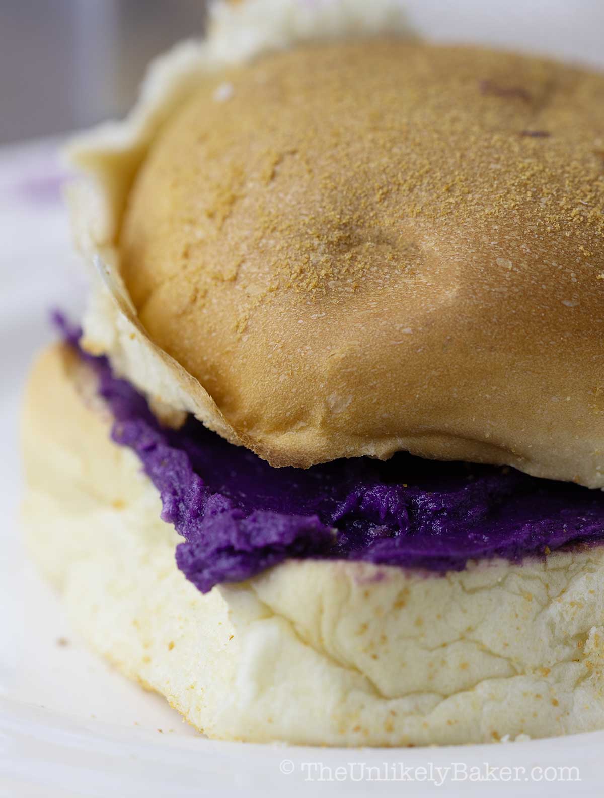 Ube butter pandesal sandwich on a plate.