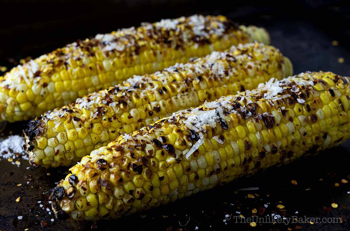 Chili corn on the cob sprinkled with parmesan cheese.